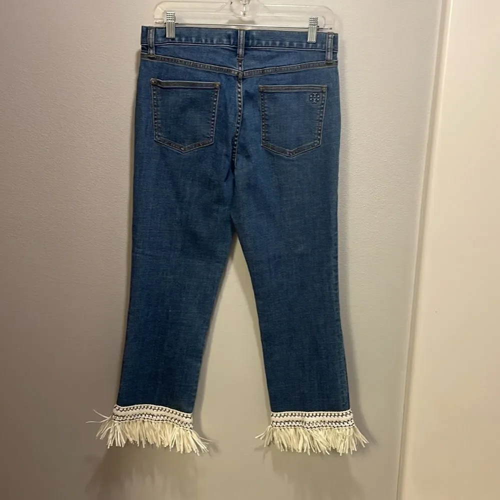 Tory Burch Connor jeans in medium allover stone wash. Cropped. Raffia fringed